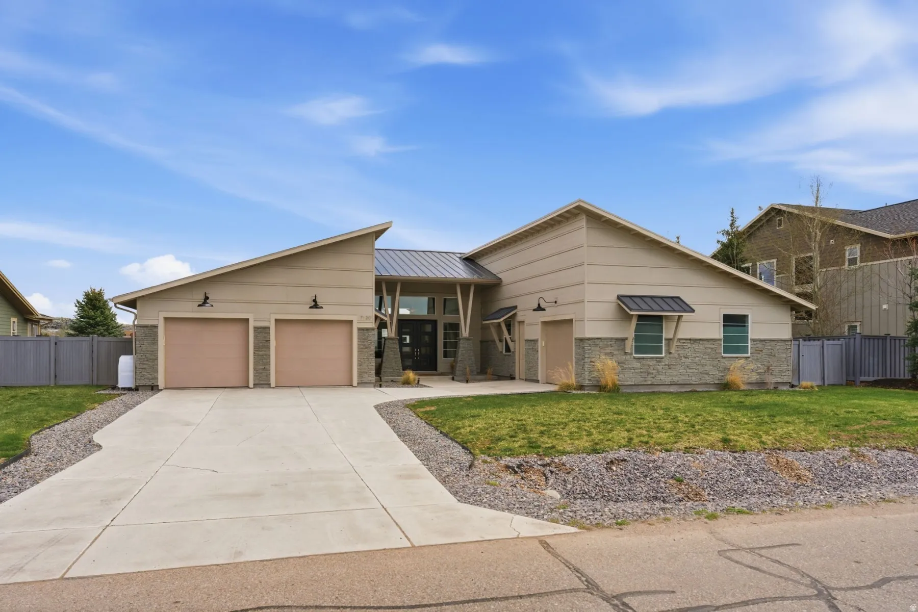 View of front of property with driveway, a garage, and a standing seam roof