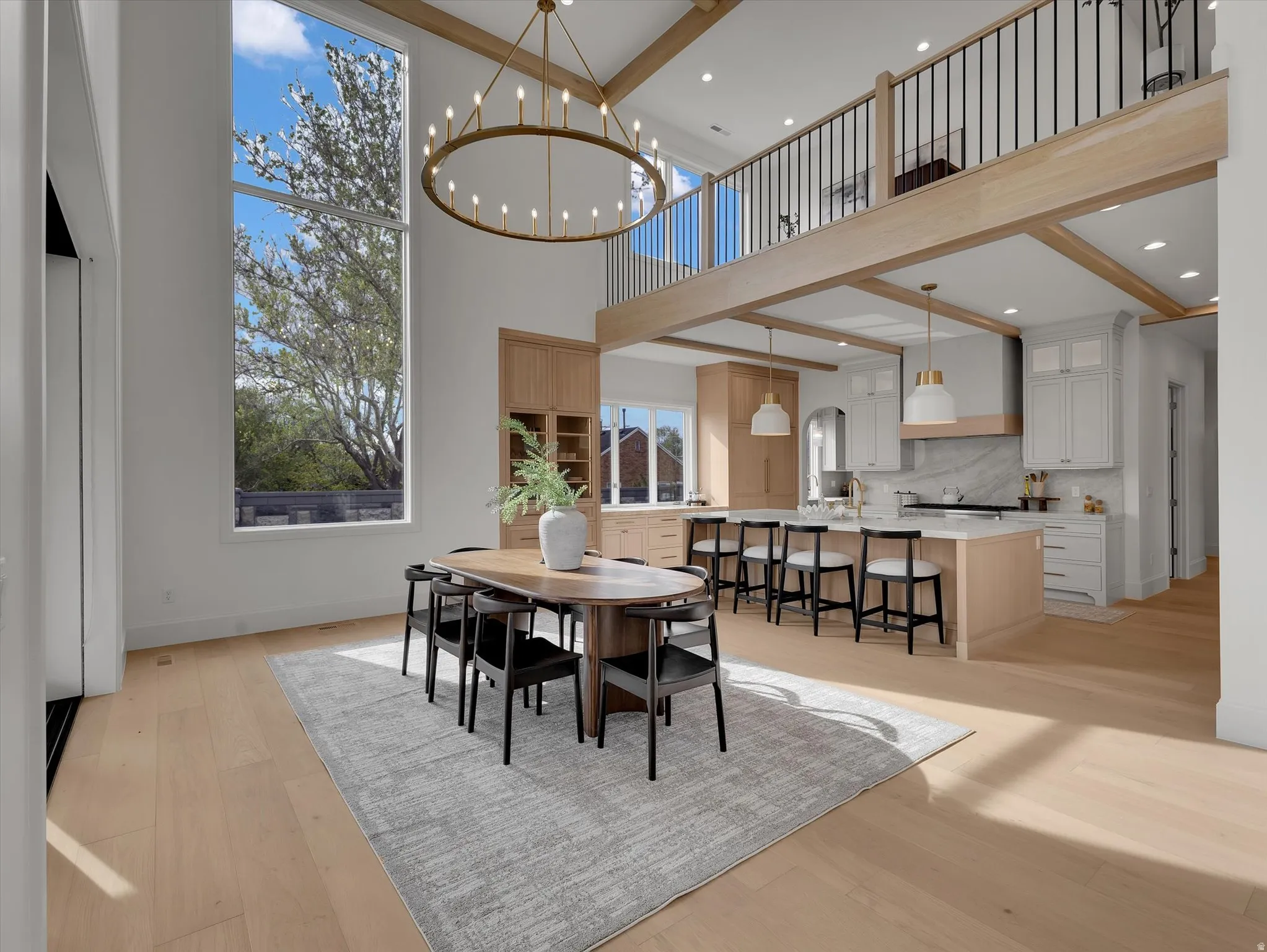 Dining area with light wood-style flooring and suspended lighting