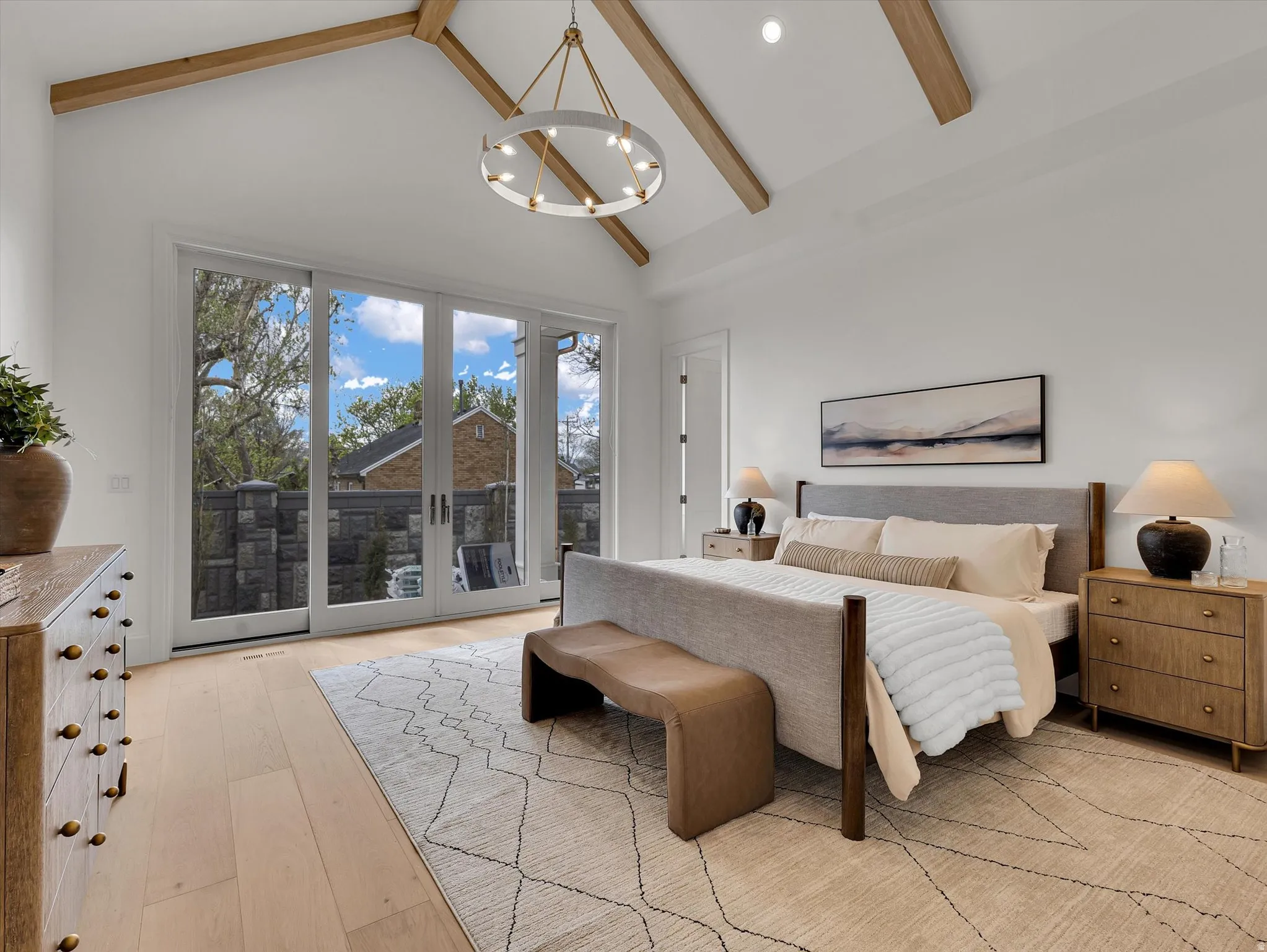 Bedroom featuring light wood-style floors, access to outside, lofted ceiling, and suspended lighting