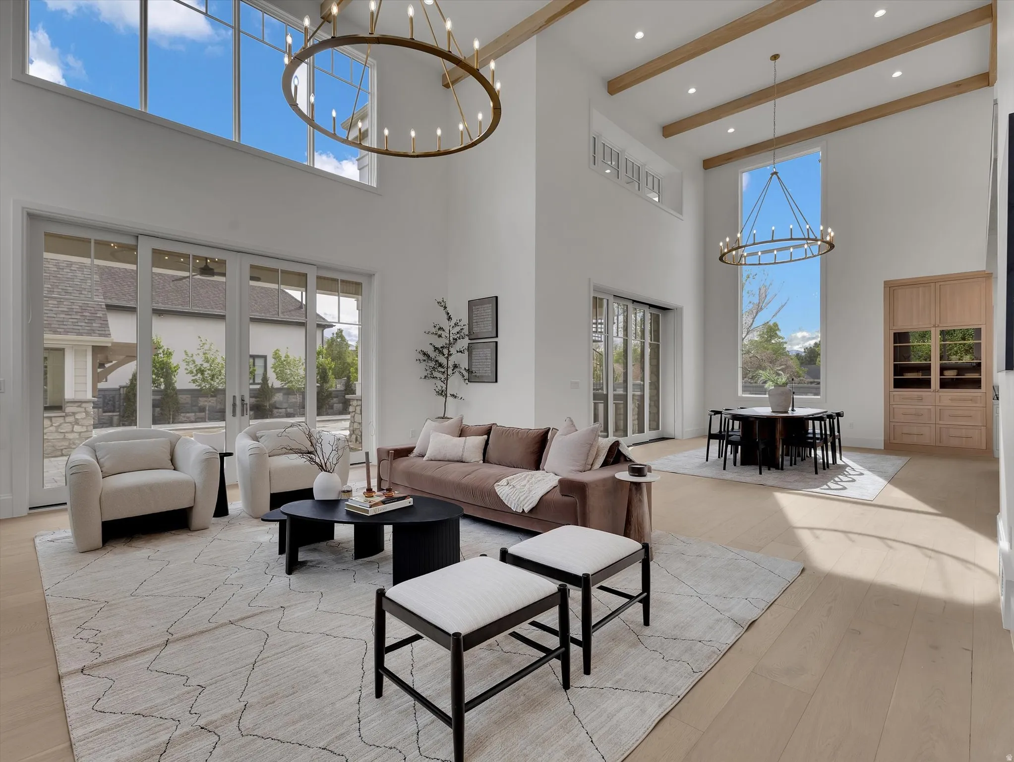 Living area featuring a chandelier, light wood-style floors, and plenty of natural light