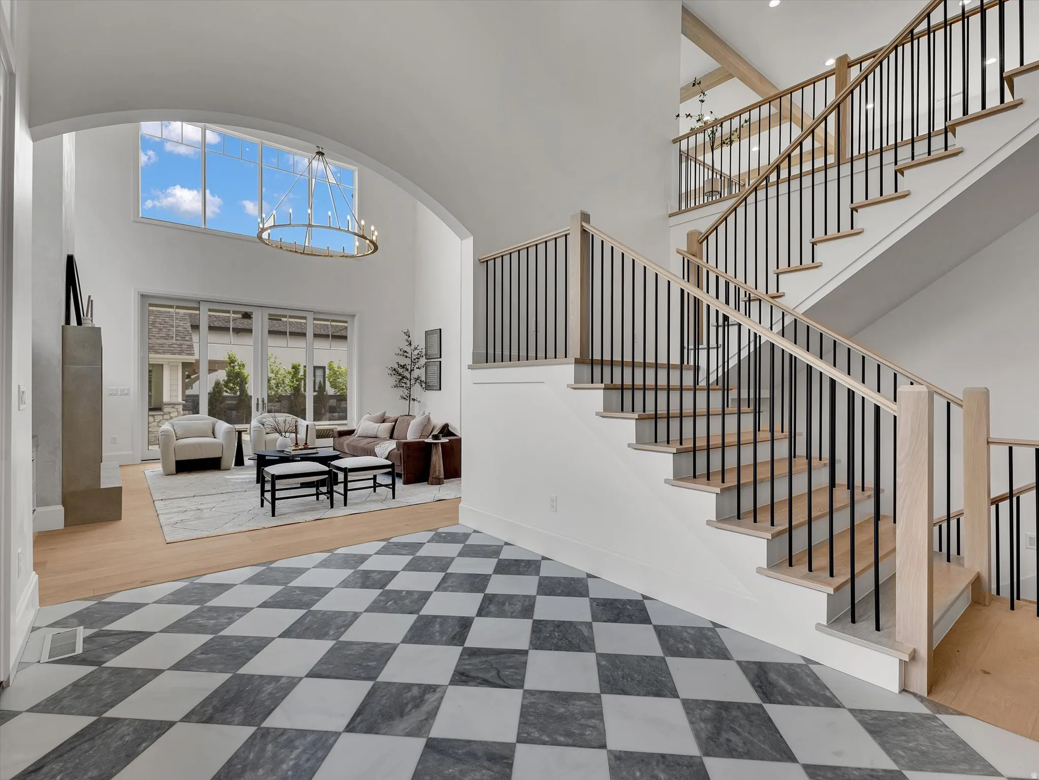 Foyer with suspended lighting, a high ceiling, and arched walkways