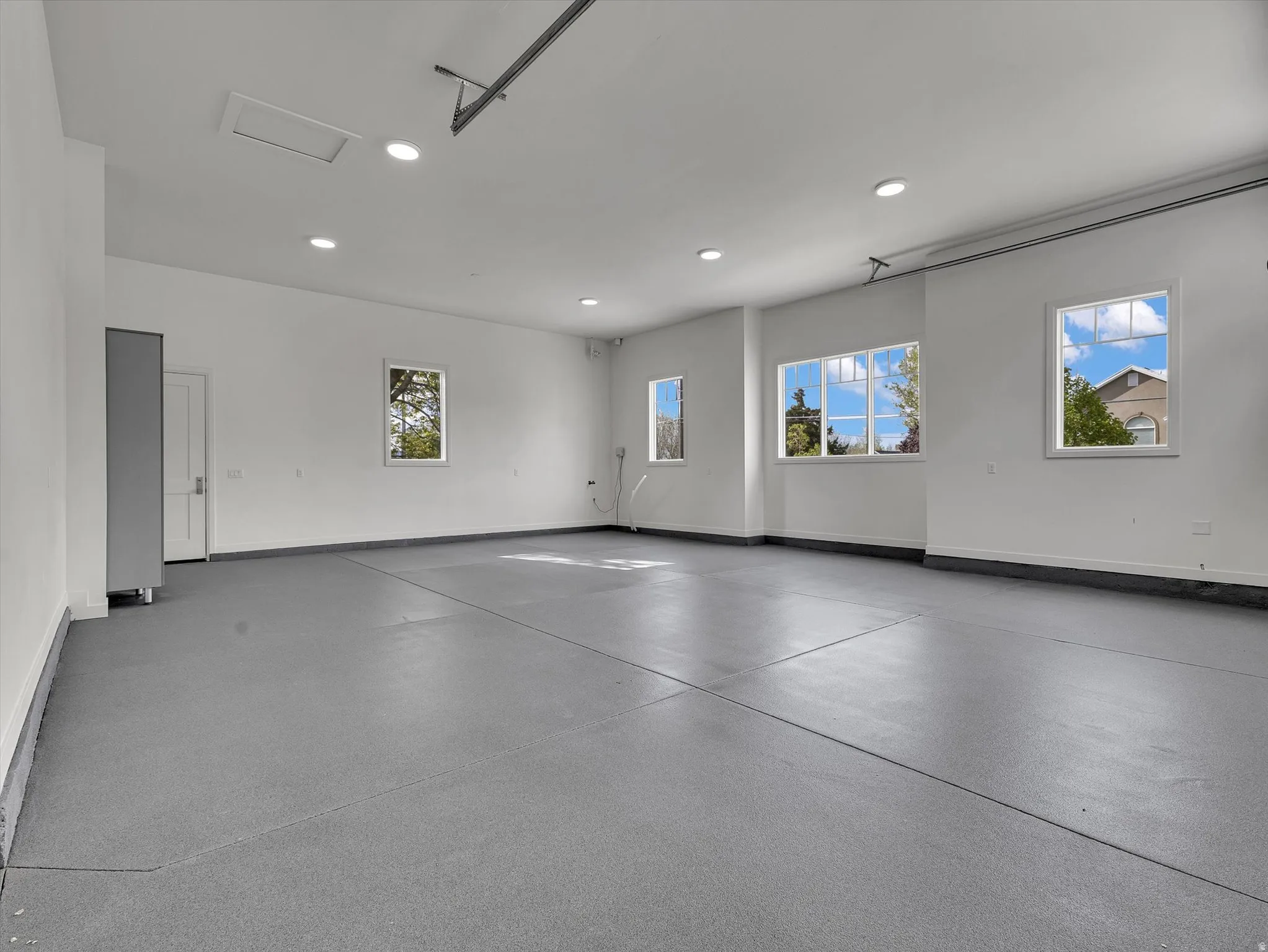 Garage featuring baseboards and recessed lighting