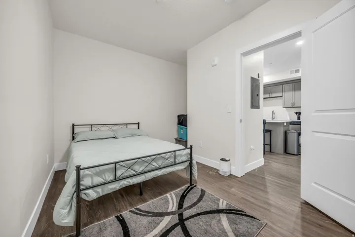 Bedroom with dark wood-style floors and electric panel