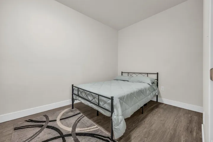 Bedroom featuring dark wood finished floors and baseboards