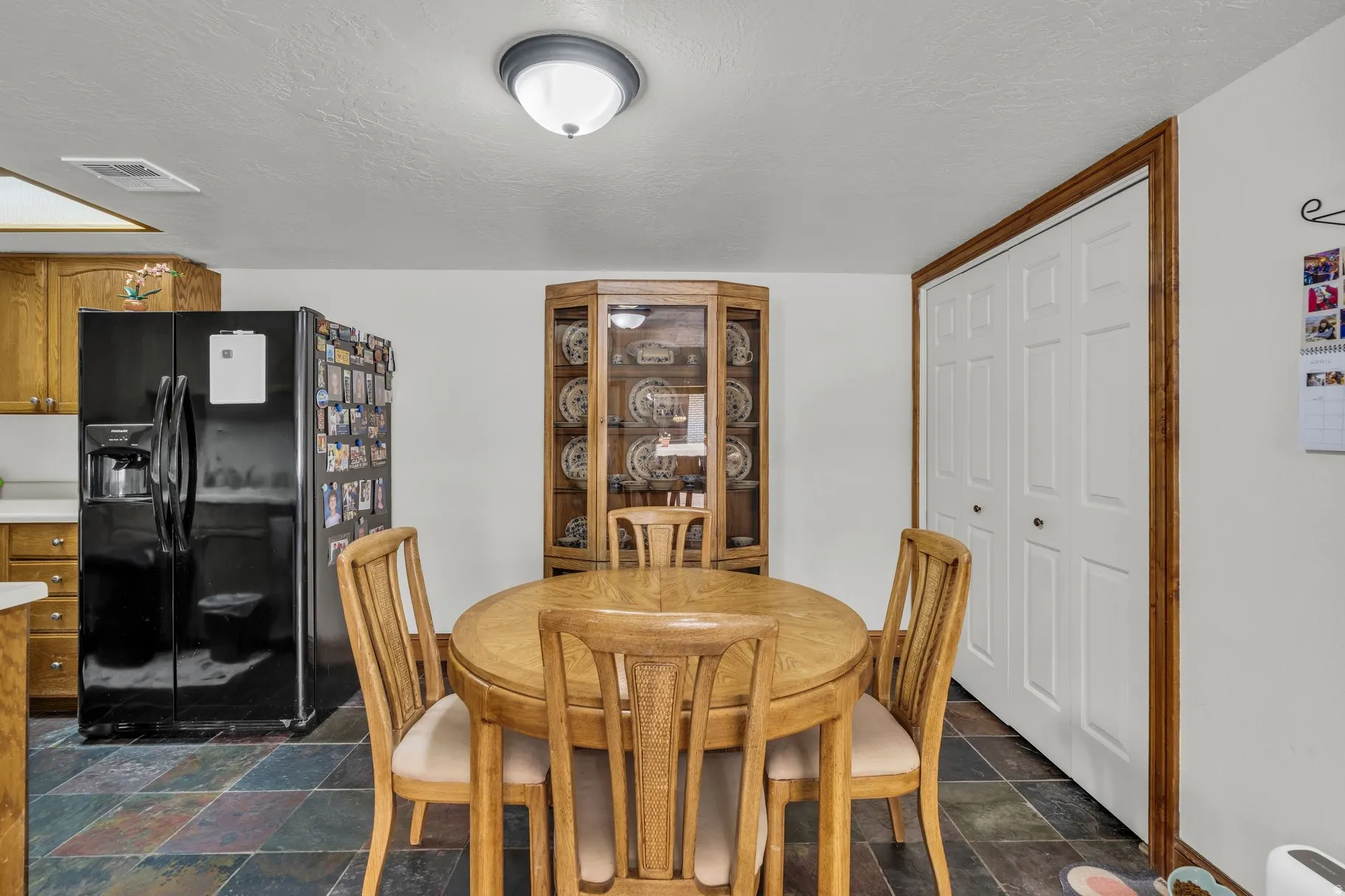 Dining room featuring dark stone finish floors and a textured ceiling
