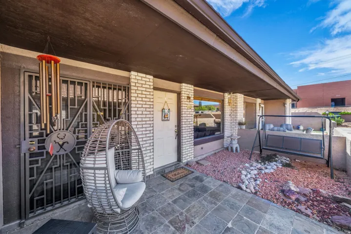Doorway to property with covered porch and brick siding