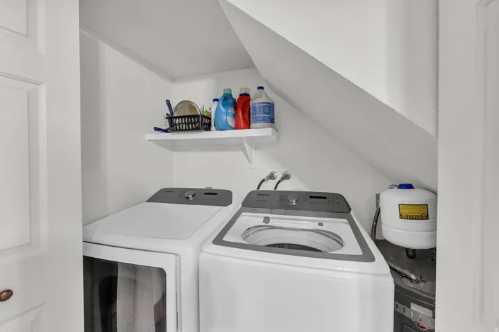 Laundry area featuring vaulted ceiling and washing machine and clothes dryer