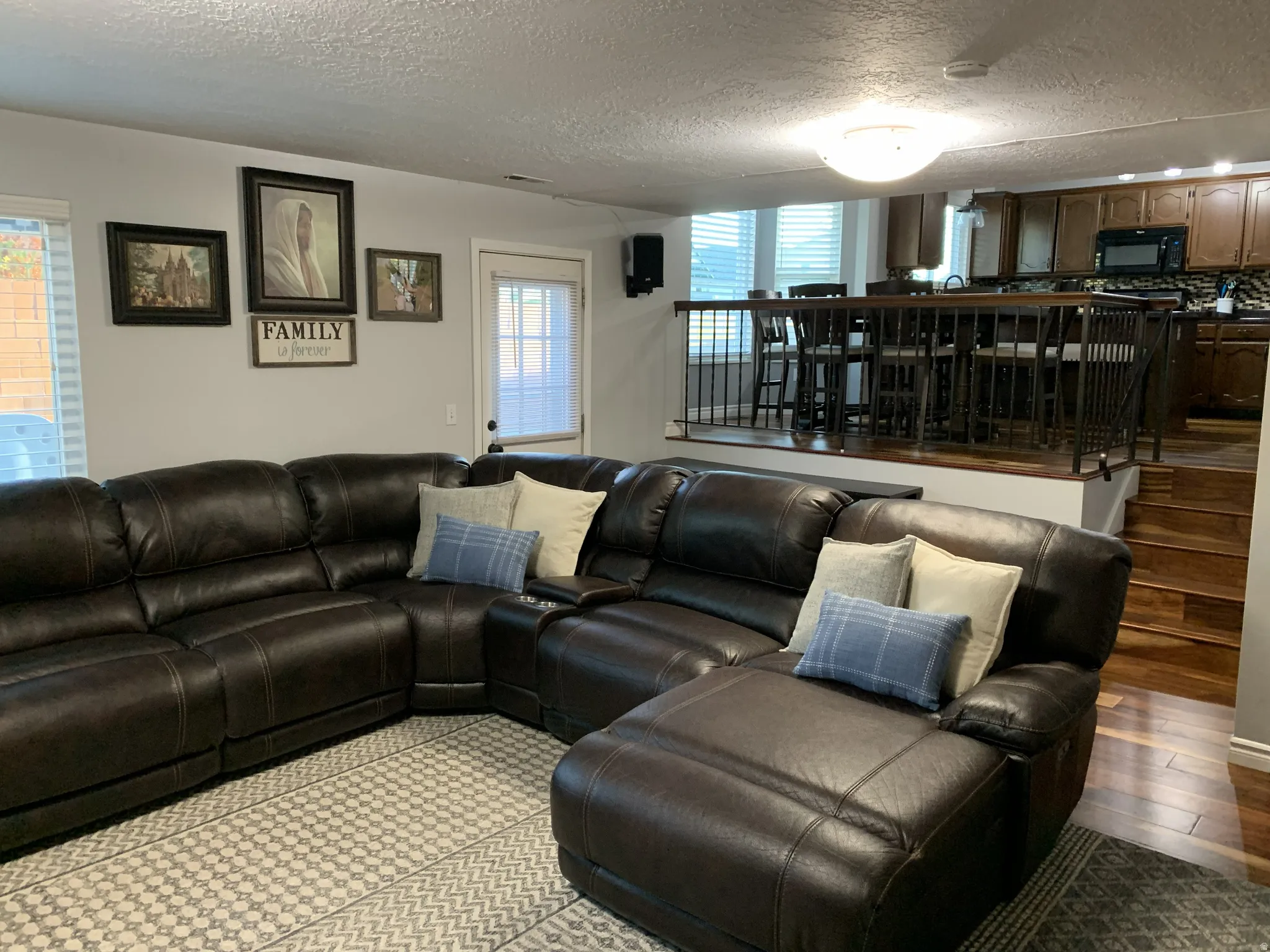 Family room area featuring a textured ceiling and hardwood floors