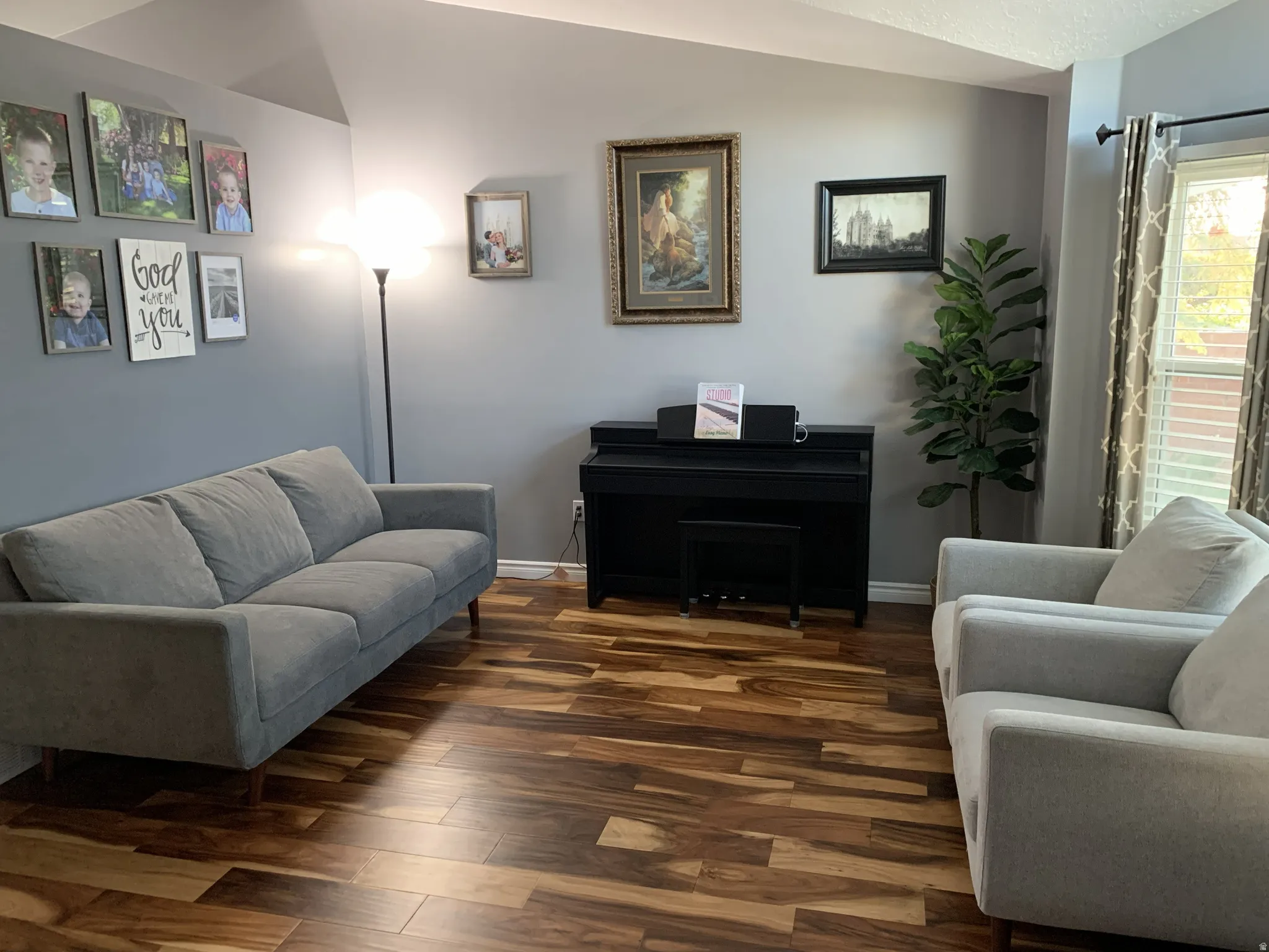Sitting room featuring vaulted ceiling and hardwood floors