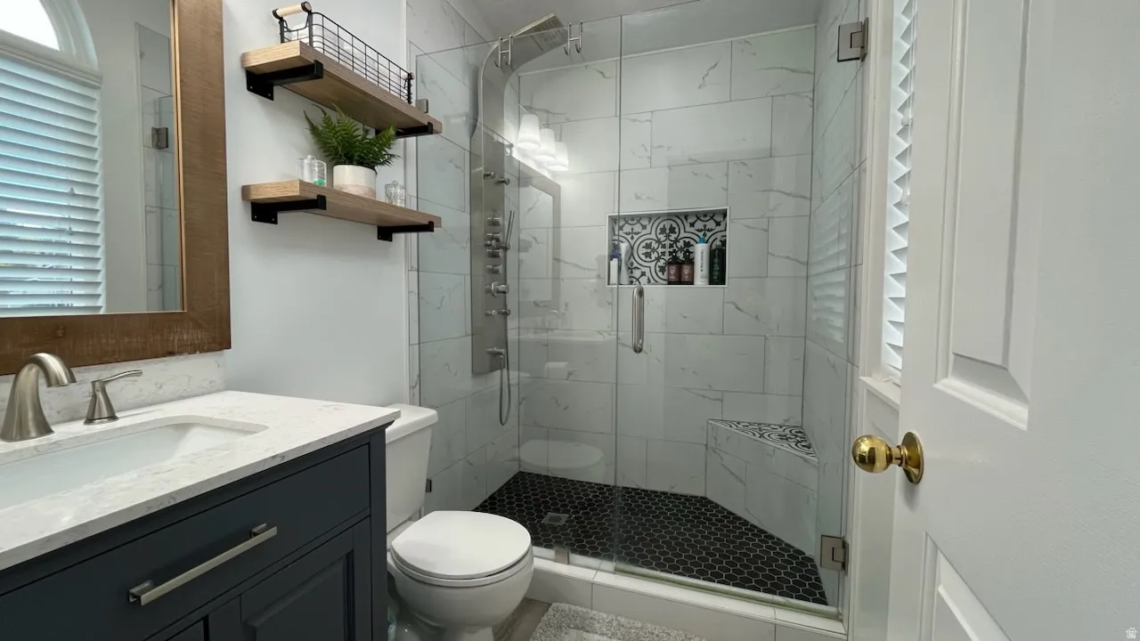 Bathroom with vanity and a marble finish shower