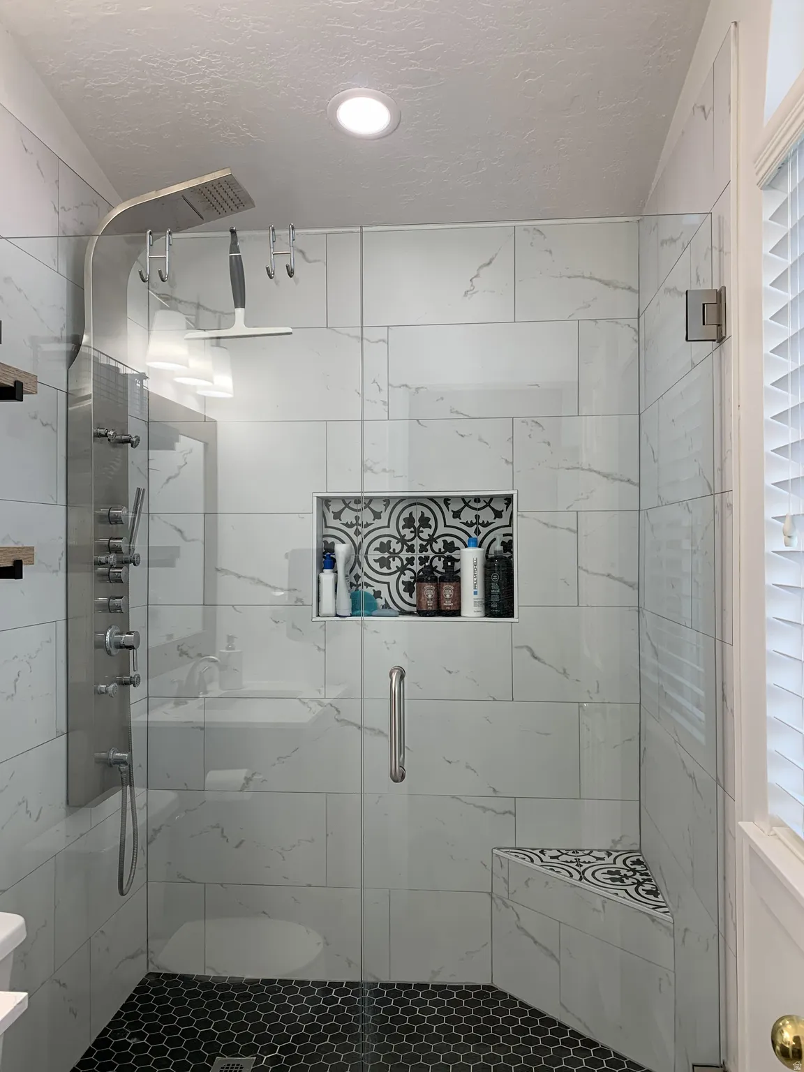 Bathroom with a textured ceiling and a marble finish shower