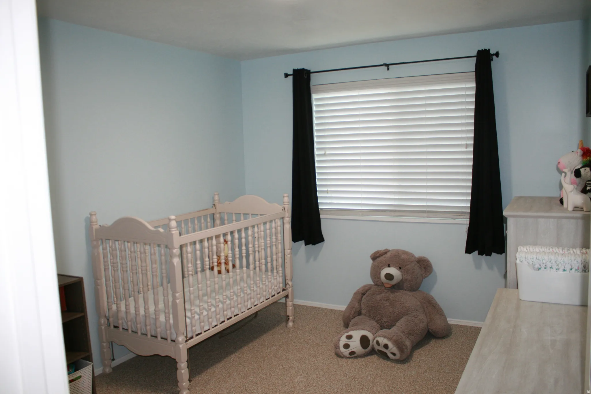 Bedroom featuring carpet flooring and a nursery area