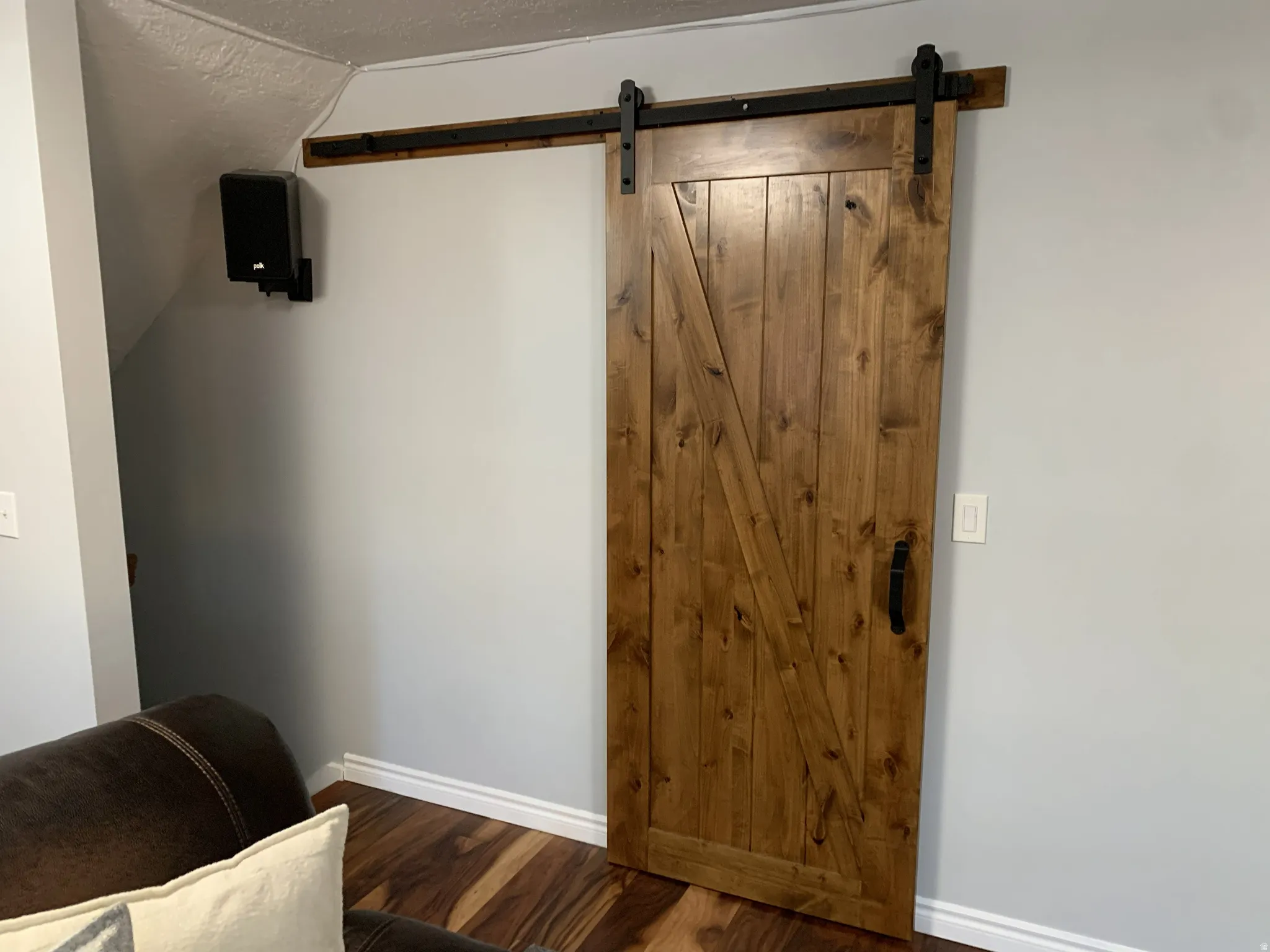 Entrance foyer with a barn door, hardwood floors, and a textured ceiling