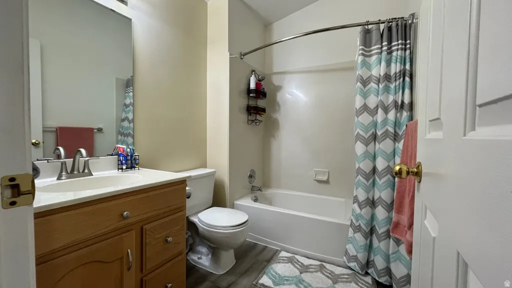 Full bathroom featuring vanity, LVP style floors, and shower / bath combination with curtain