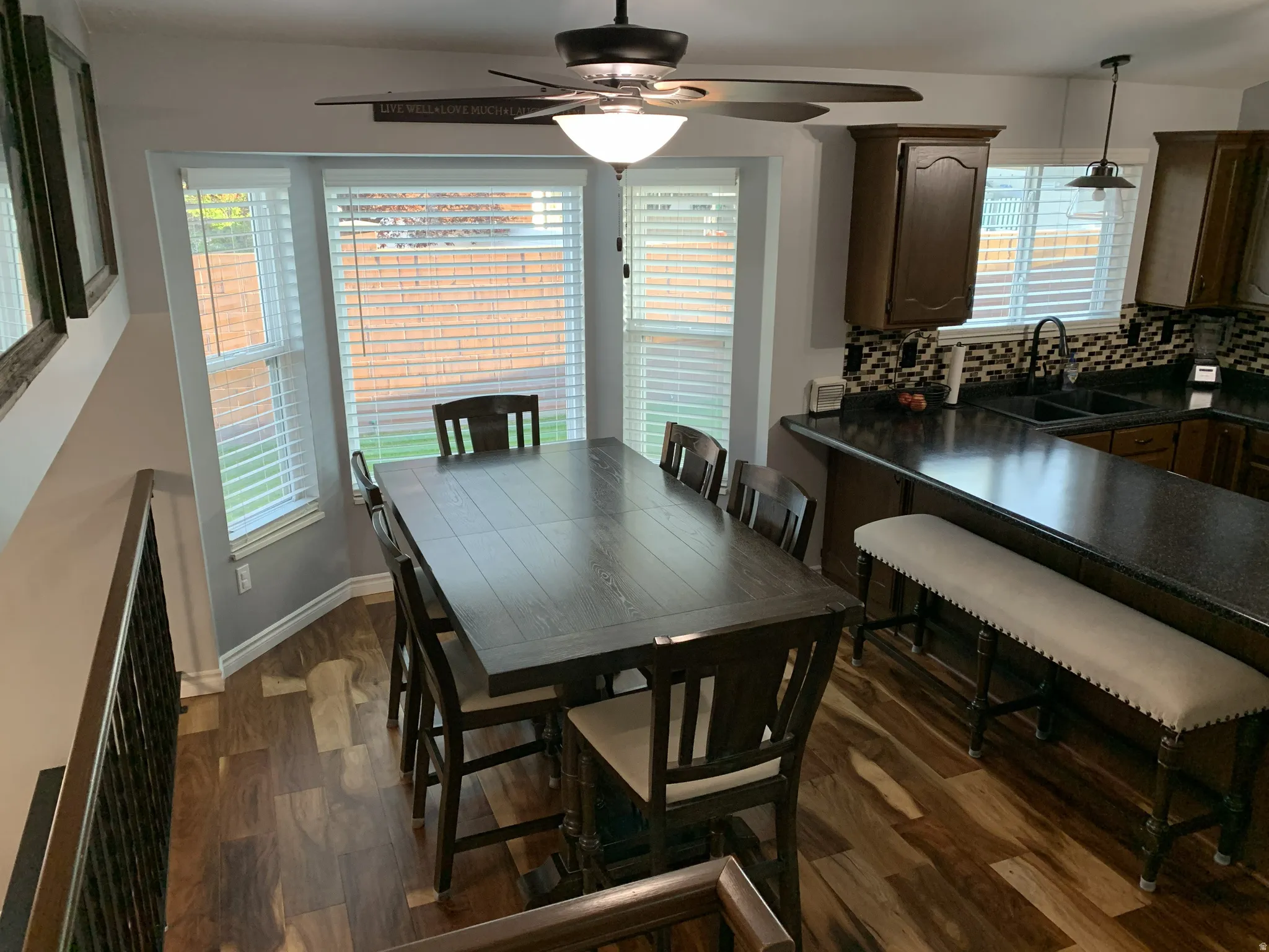 Dining space with hardwood floors and a ceiling fan