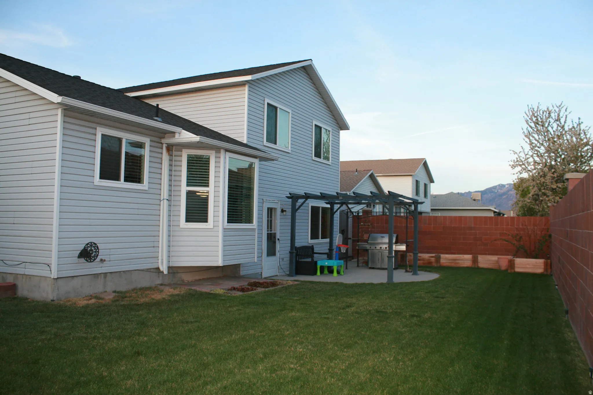 Rear view of house featuring a patio area, a pergola, and a fenced backyard