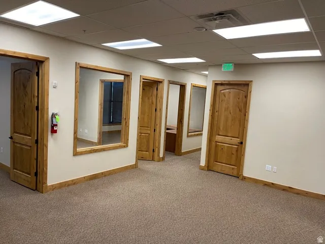 Interior space with a paneled ceiling and baseboards