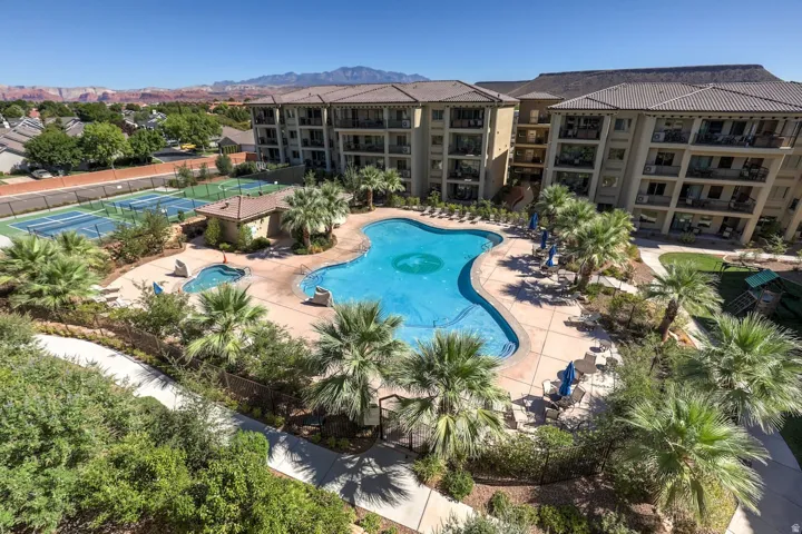 Community pool with a patio and a tennis court