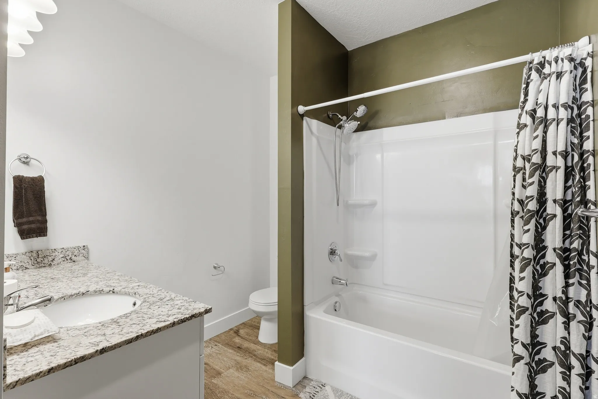 Full bath featuring vanity, shower / bath combo with shower curtain, and light wood-type flooring