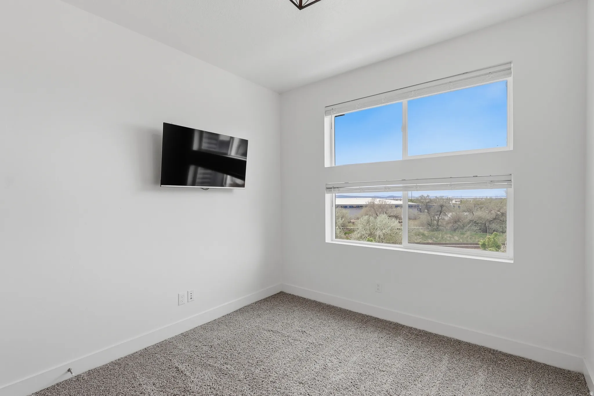 Spare room with baseboards and light carpet