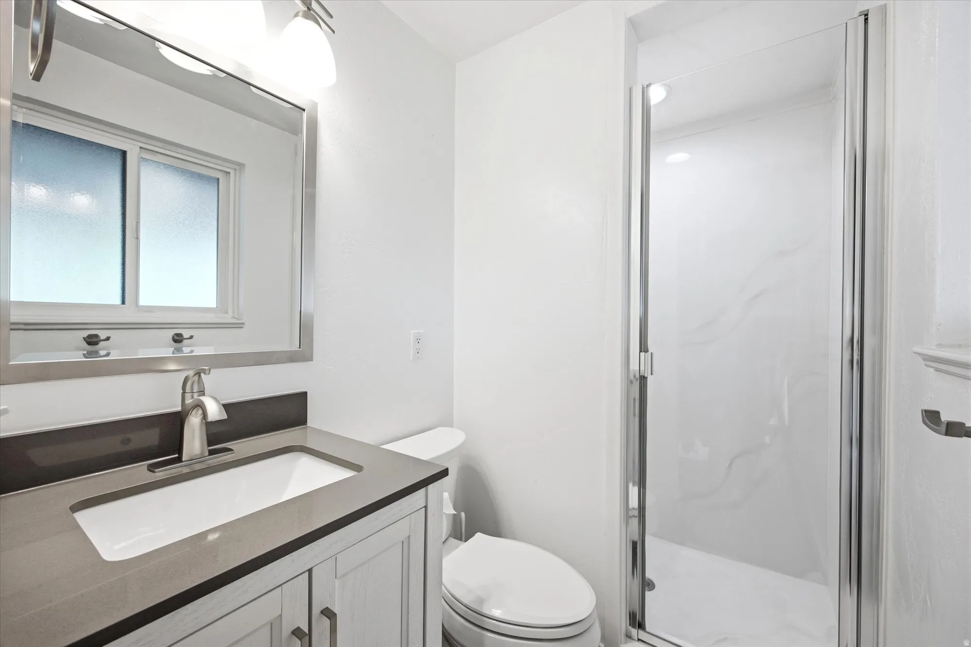 Full bath featuring vanity and a marble finish shower