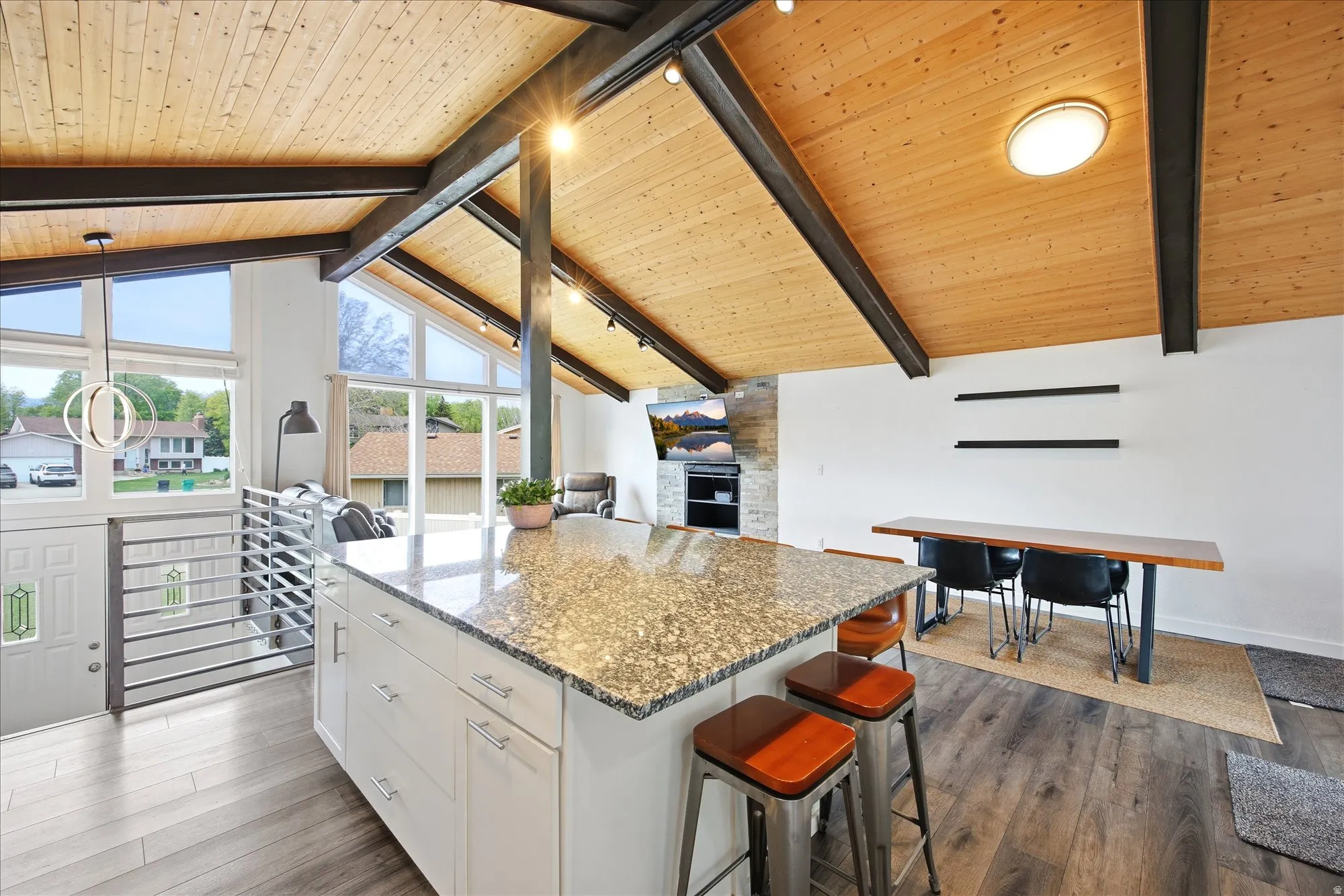 Kitchen featuring light stone counters, a kitchen island, a kitchen breakfast bar, dark wood finished floors, and a high wood beamed ceiling