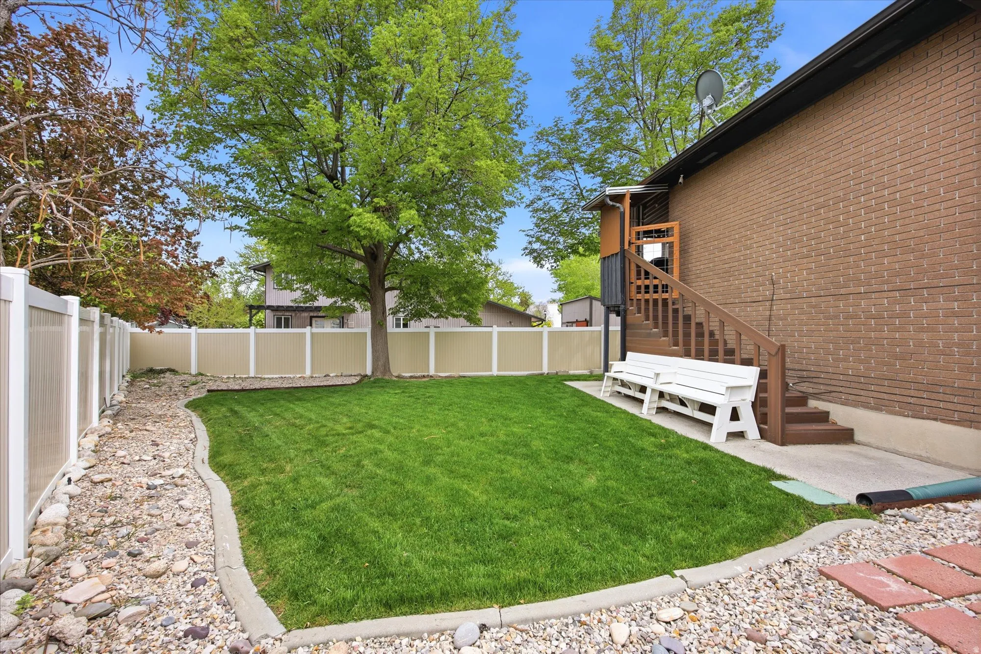 Fenced backyard with a patio area and stairs