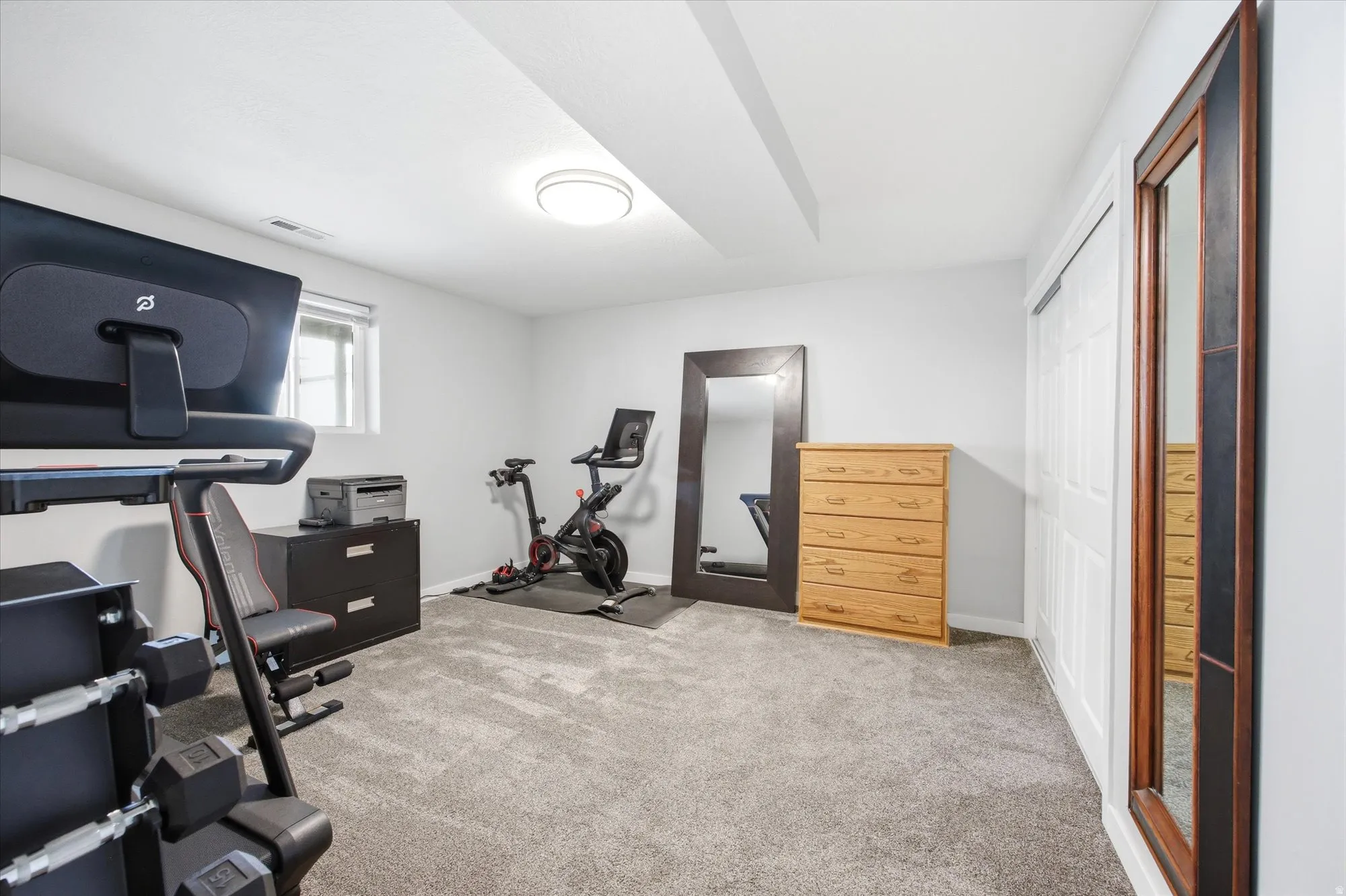 Workout room featuring light colored carpet and baseboards