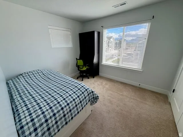 Bedroom featuring light carpet and baseboards