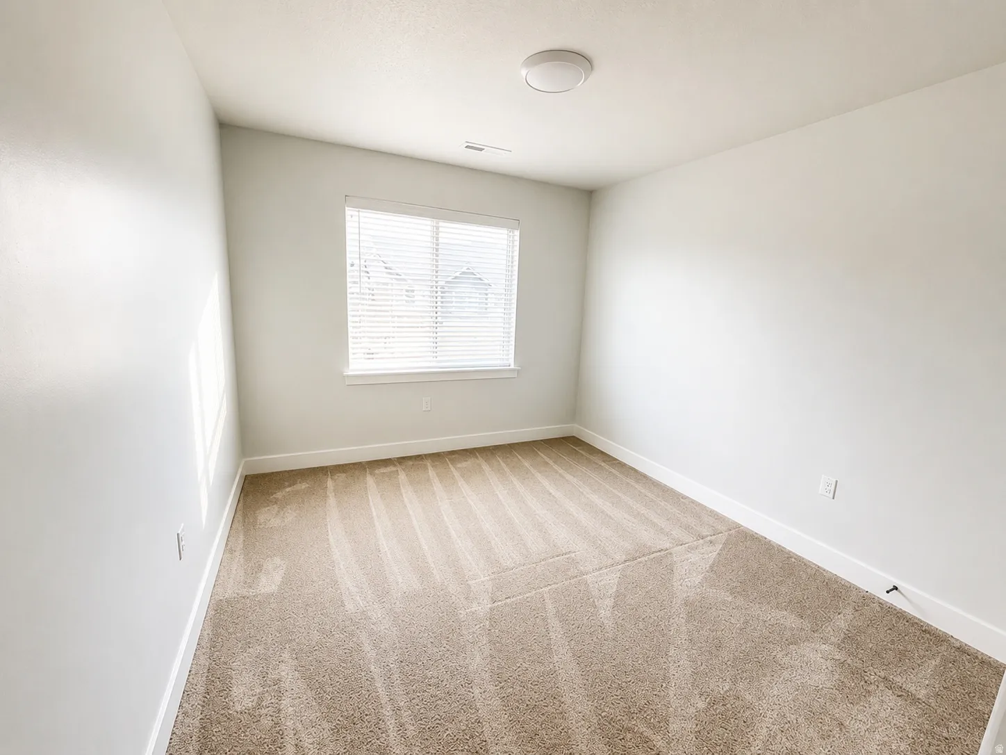 Room featuring neutral tone carpeting and white baseboards