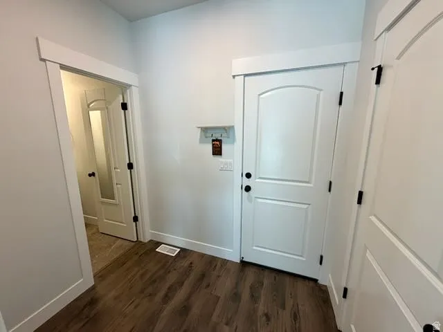 Doorway to outside featuring wood finished floors and baseboards