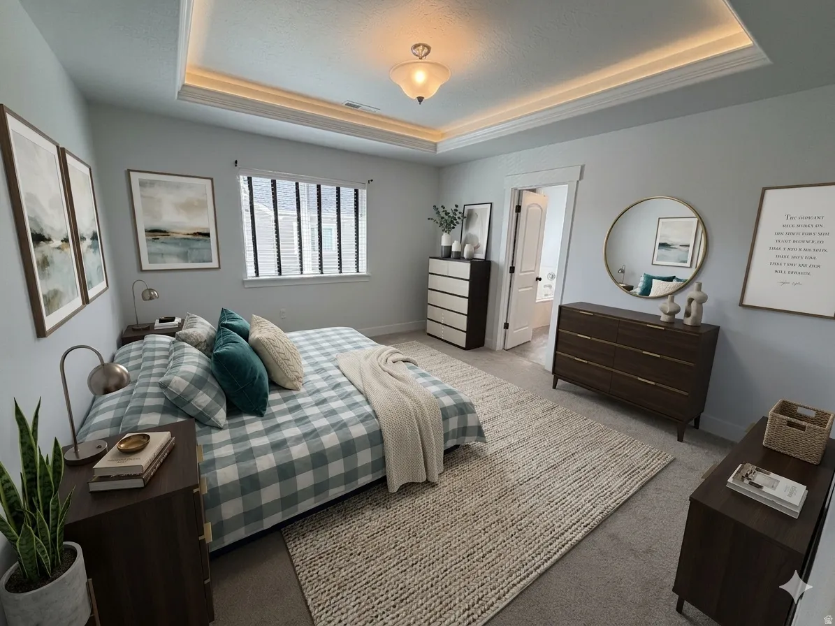 Bedroom with carpet, connected bathroom, and a raised ceiling