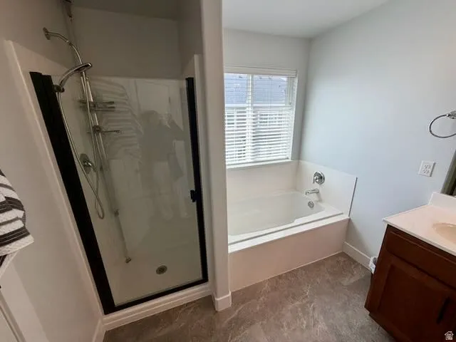 Bathroom with vanity, a garden tub, and a shower stall