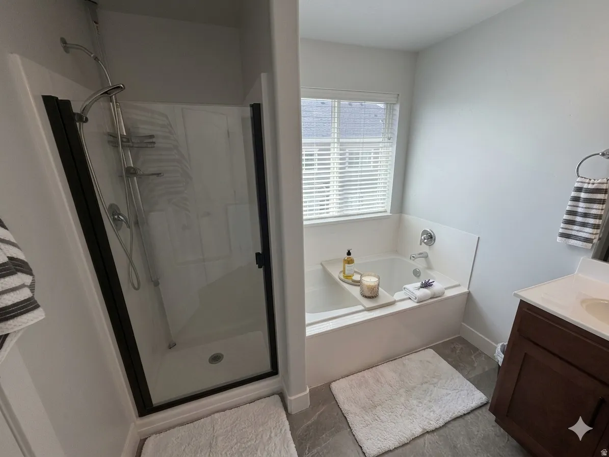 Full bathroom featuring vanity, a bath, and a shower stall