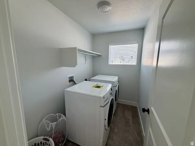 Laundry room with washing machine and clothes dryer and a textured ceiling
