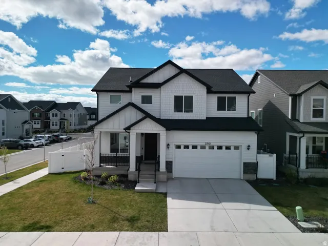 View of front of home with board and batten siding, covered porch, a residential view, concrete driveway, and a garage