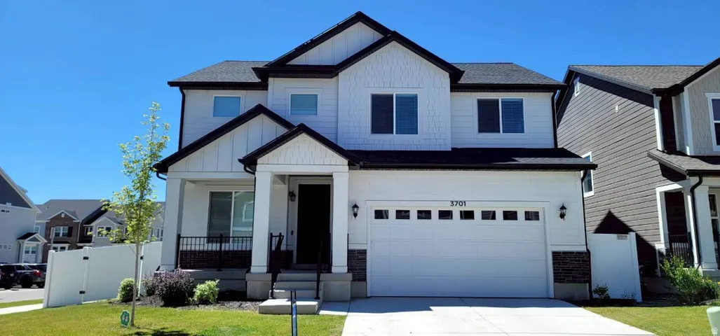 Contemporary two-story residence featuring a white exterior with dark trim accents