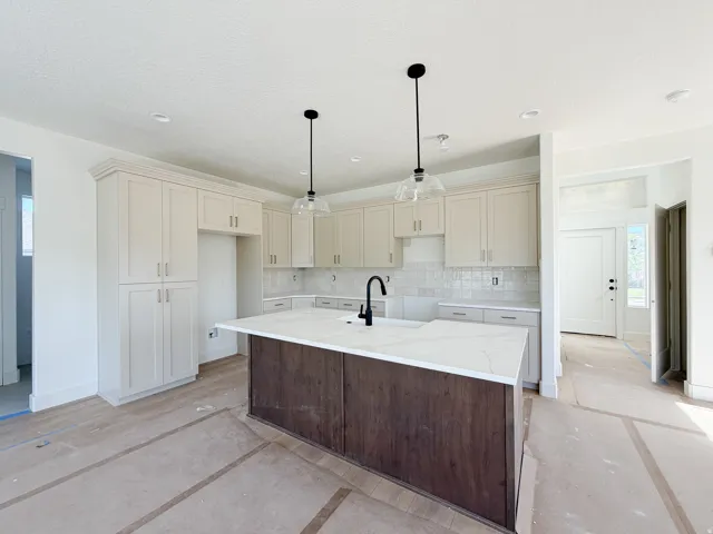 Kitchen featuring an expansive center island with a stone-finish countertop and wood-finish cabinetry