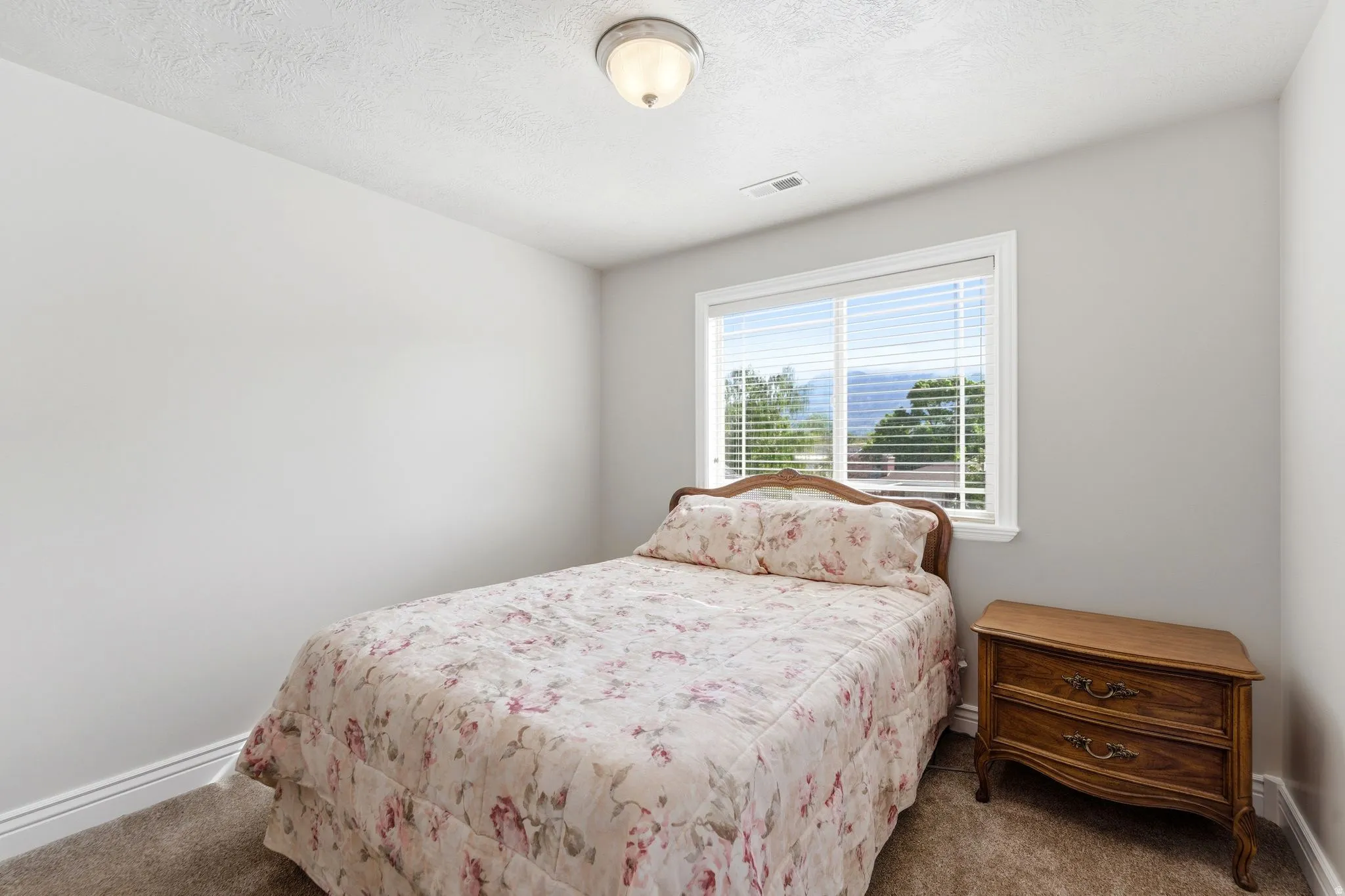 Carpeted bedroom with baseboards and a textured ceiling