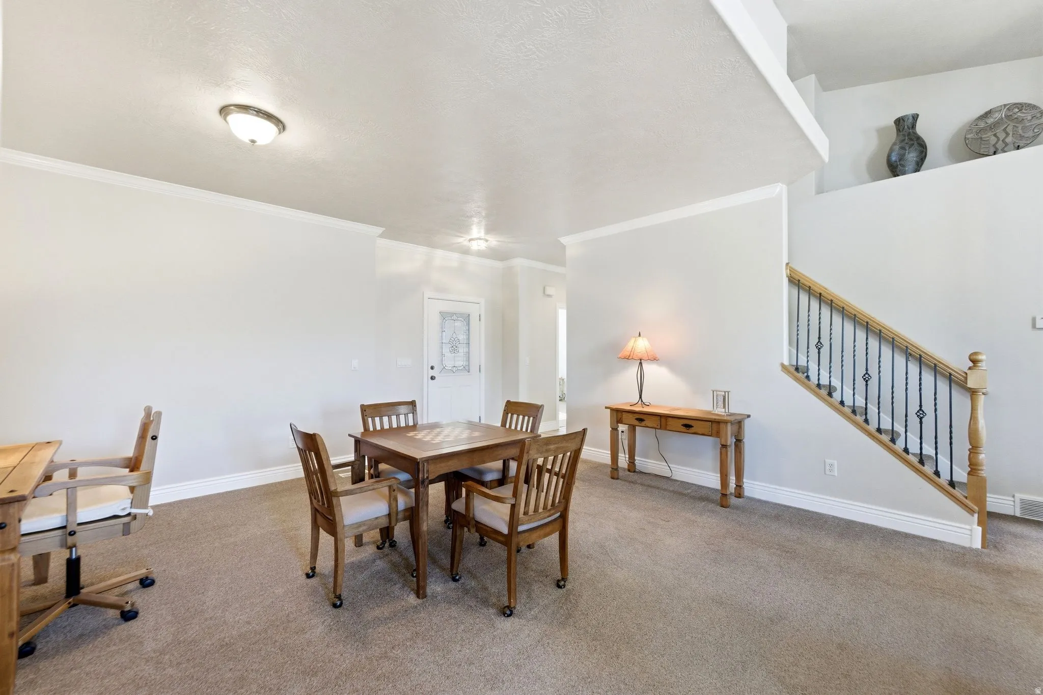 Carpeted dining area featuring stairway and ornamental molding