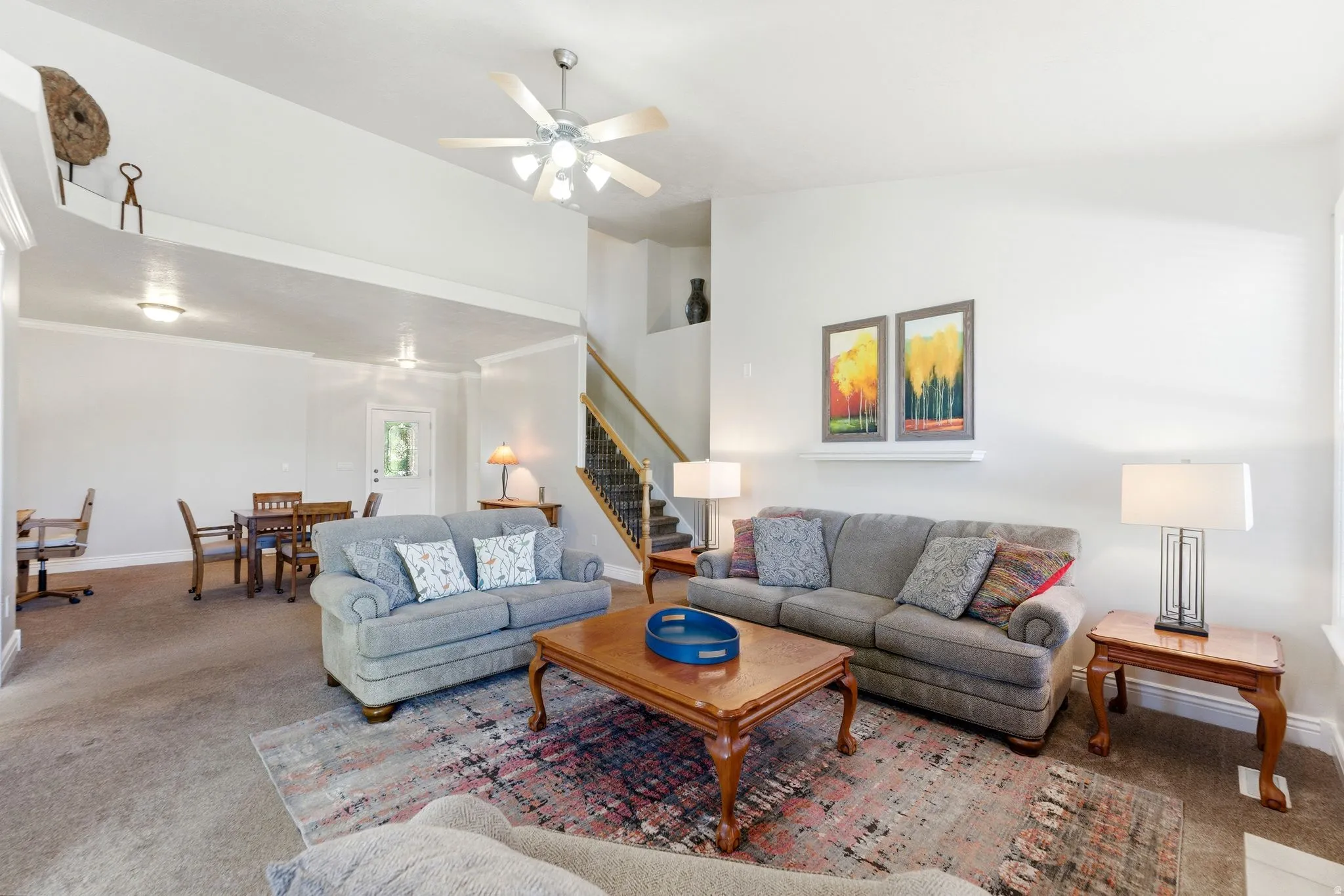 Living room featuring carpet flooring and a ceiling fan