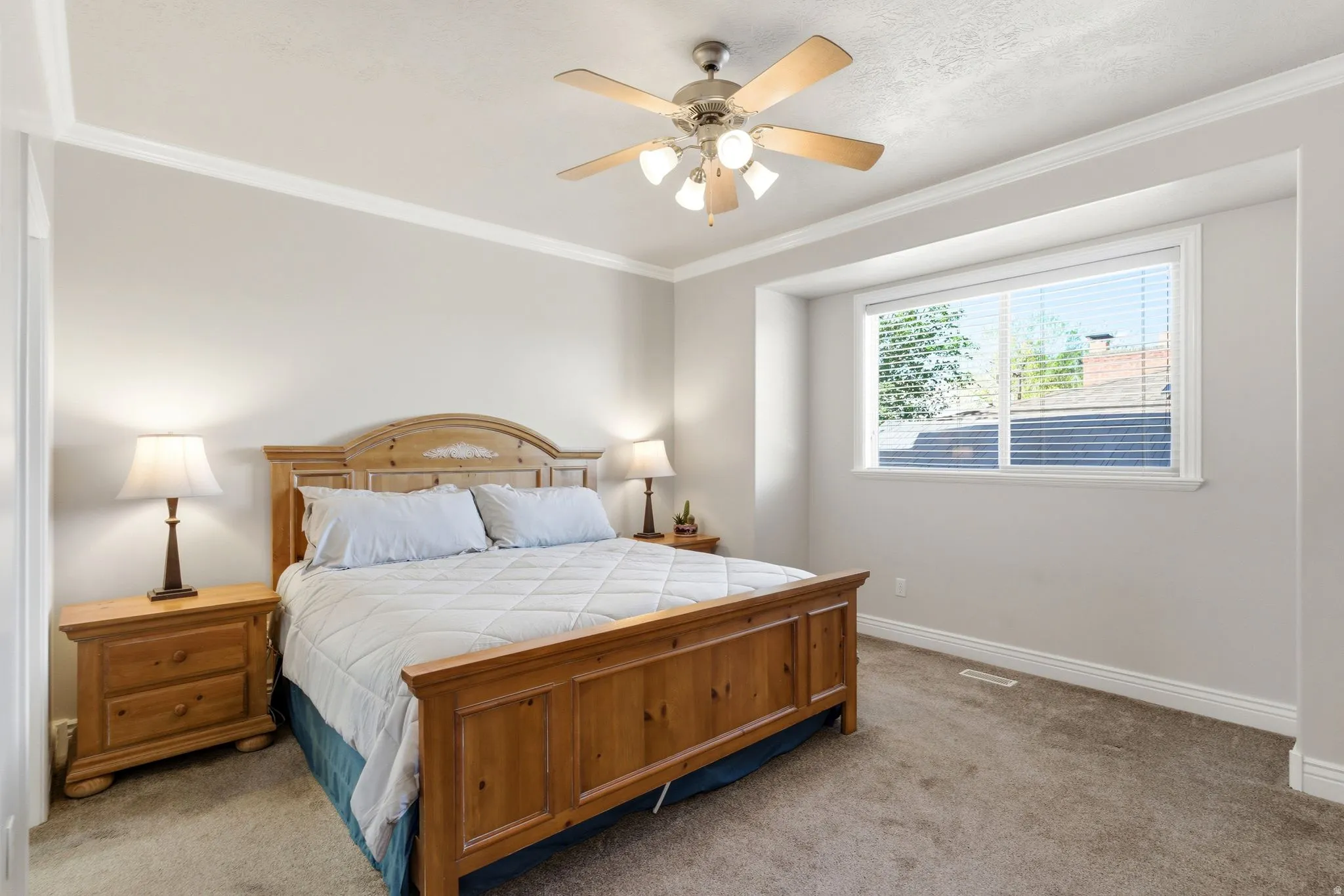 Bedroom featuring carpet, ceiling fan, and crown molding