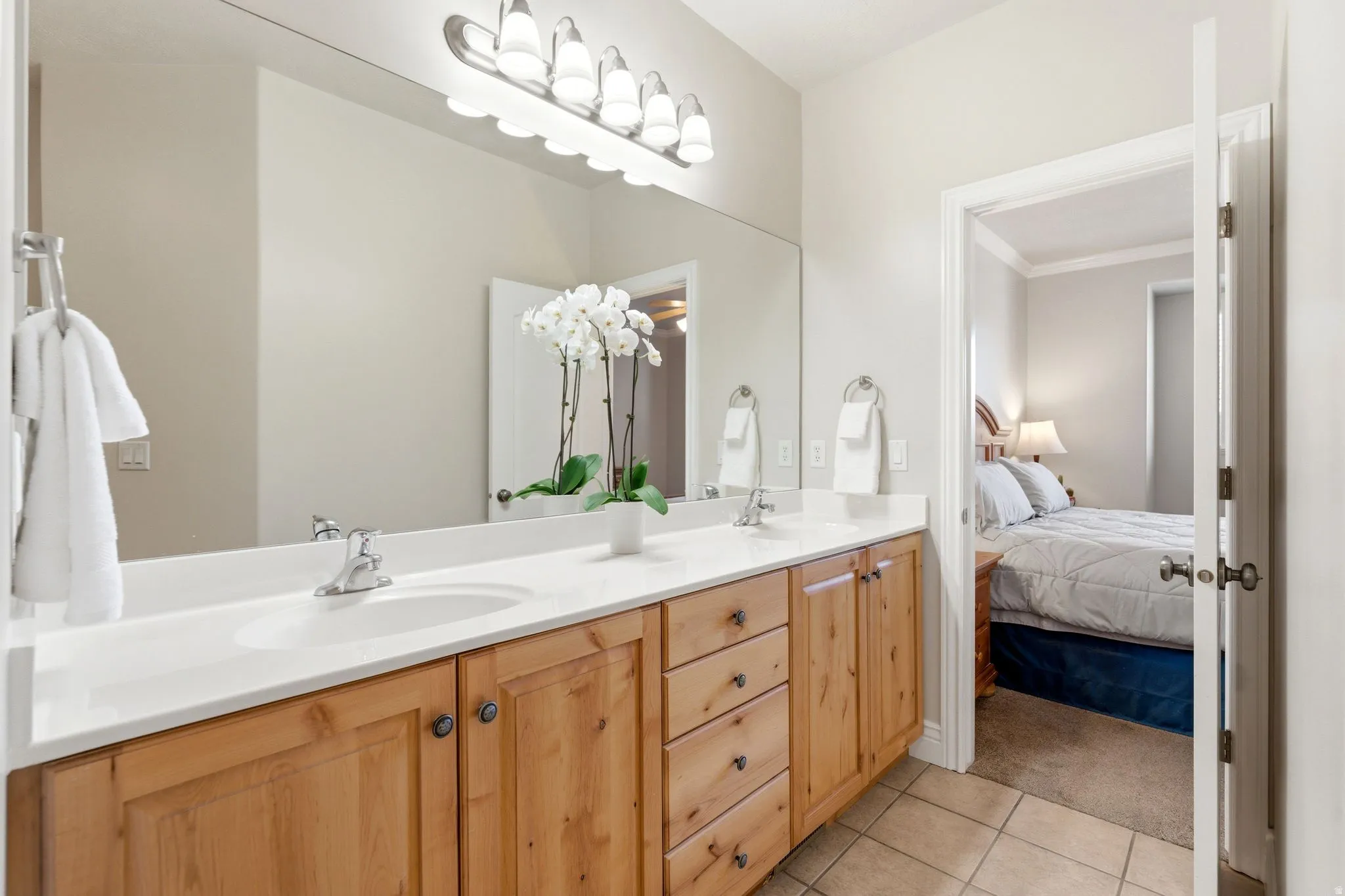 Bathroom featuring double vanity, ensuite bathroom, and light tile patterned floors