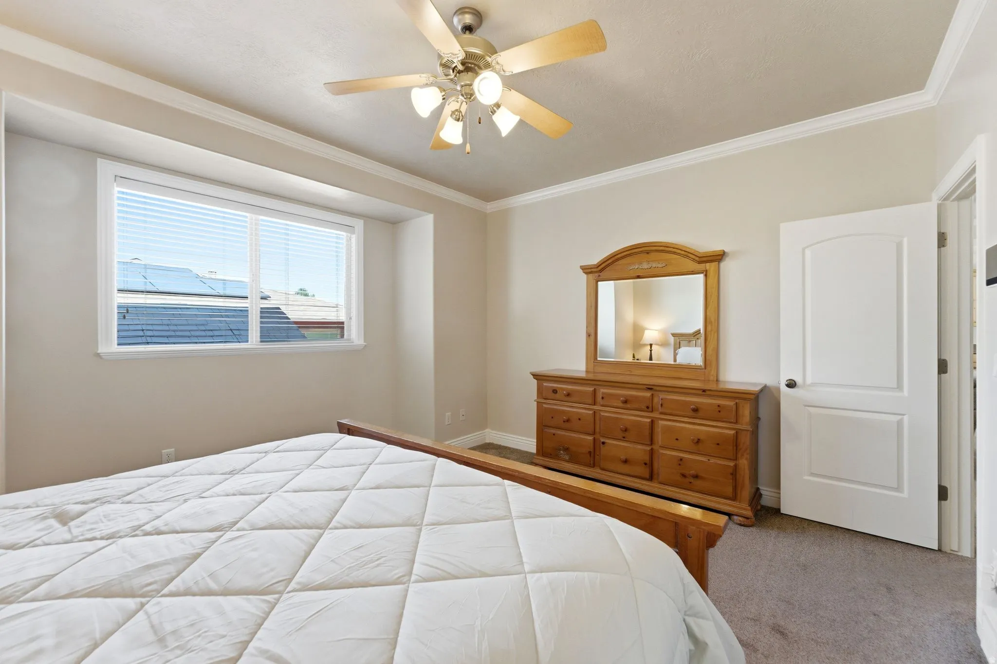 Bedroom featuring ornamental molding, carpet flooring, and ceiling fan