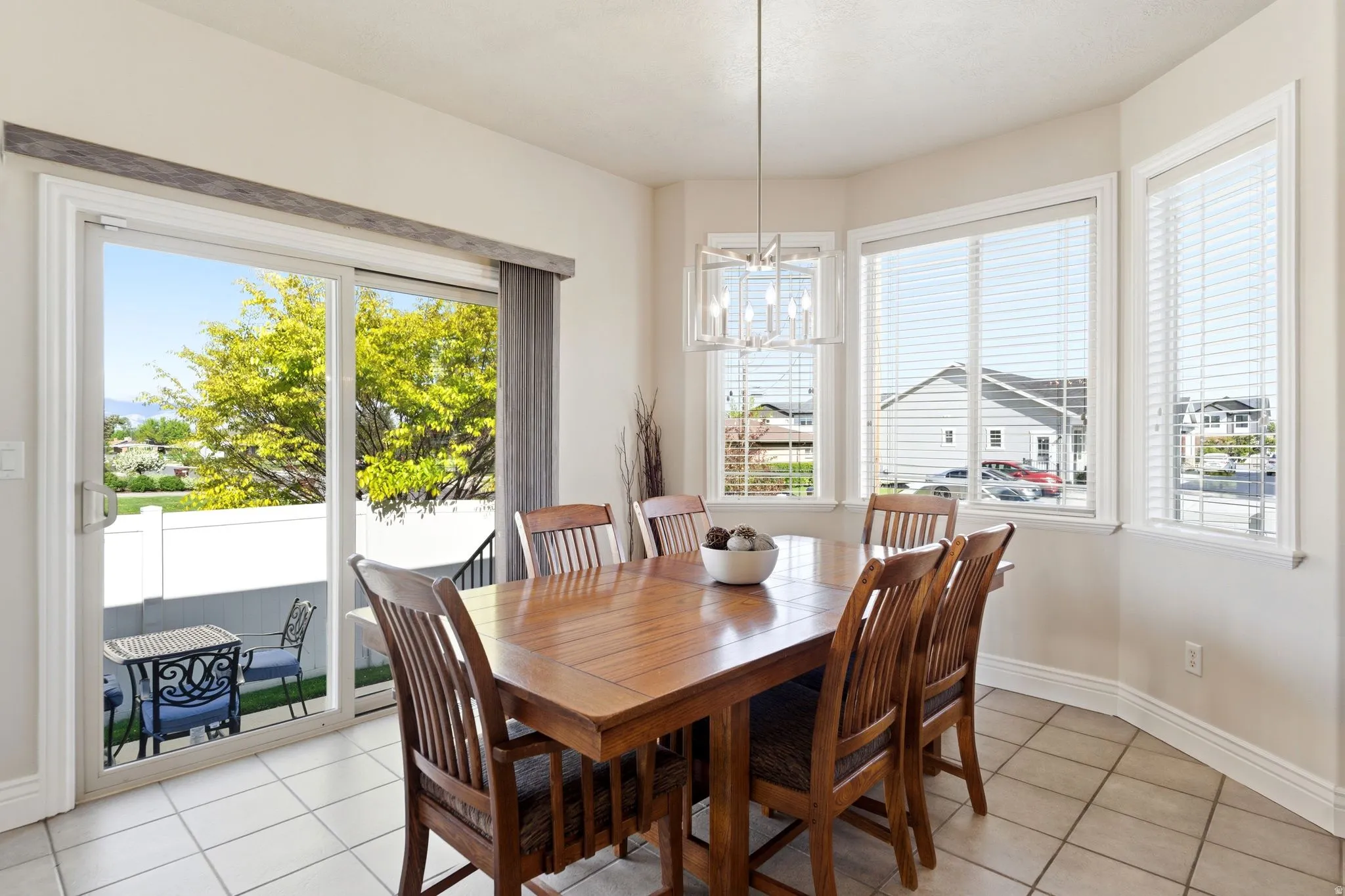 Dining space with light tile patterned floors, plenty of natural light, and hanging lights