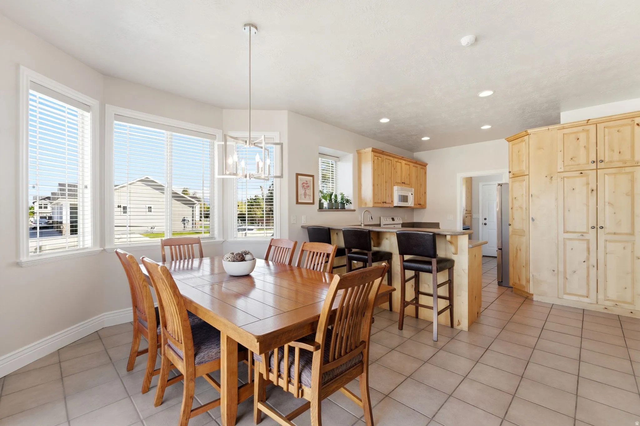 Dining area with light tile patterned flooring and suspended lighting