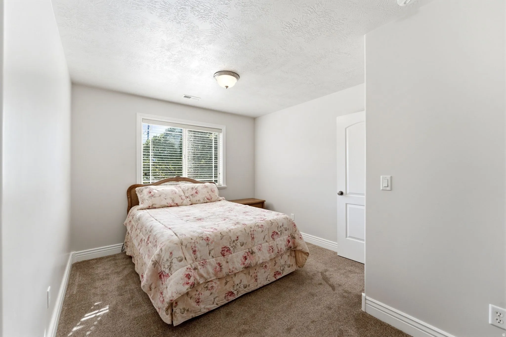 Bedroom with a textured ceiling and carpet flooring