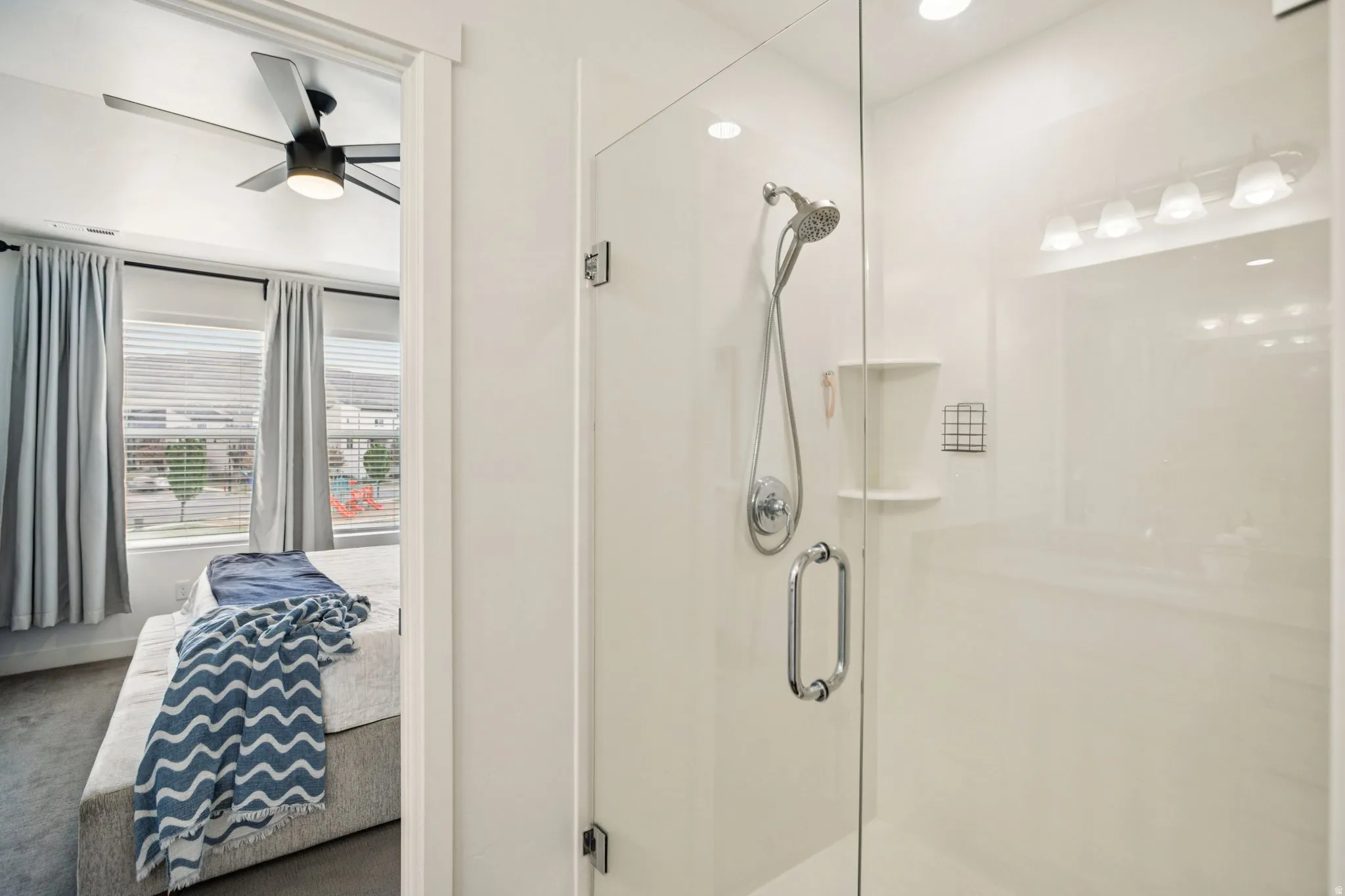 Bathroom featuring a stall shower, a ceiling fan, and ensuite bath