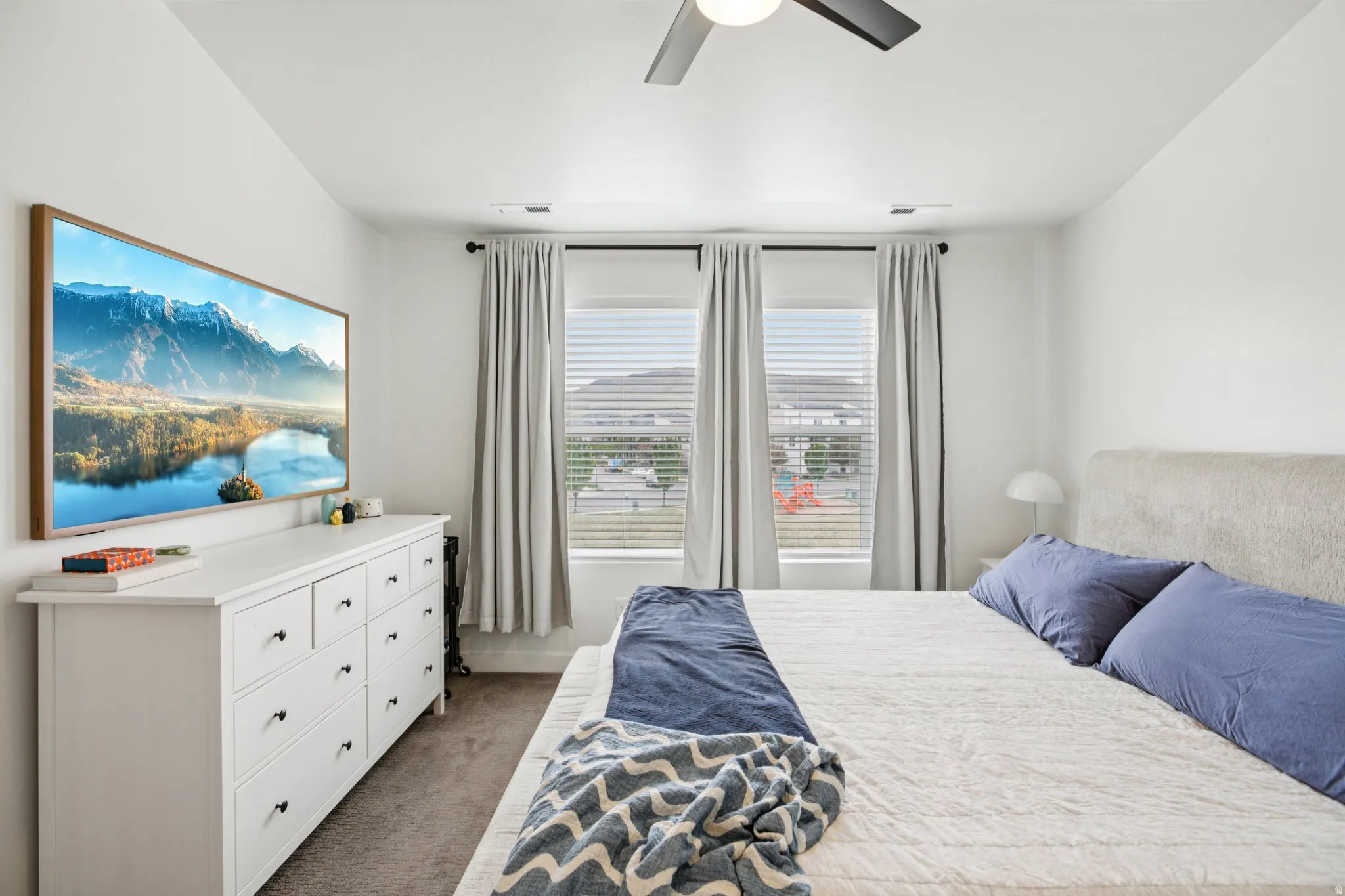 Bedroom featuring dark carpet, a mountain view, and a ceiling fan