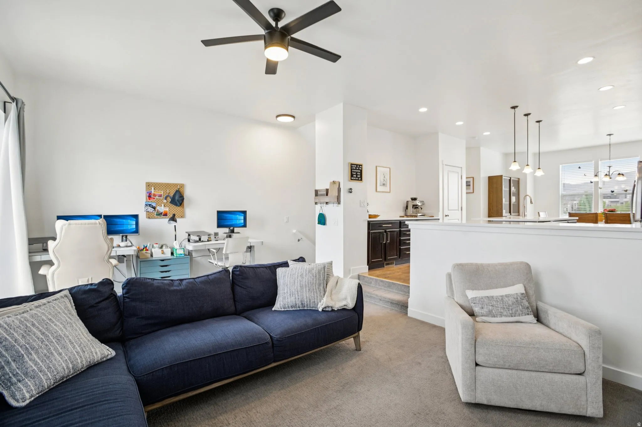 Living room with recessed lighting, an office area, dark colored carpet, and ceiling fan